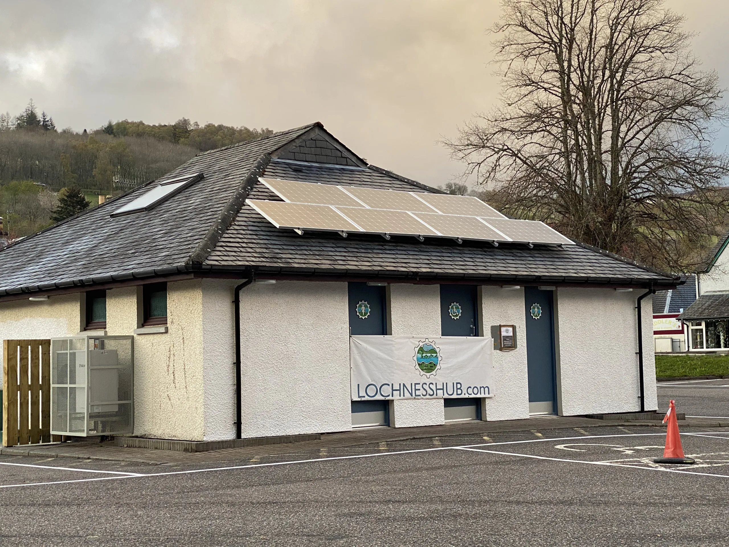 The Loch Ness Hub building with our solar array on the roof and the heat pump in its protective cage beside the wall